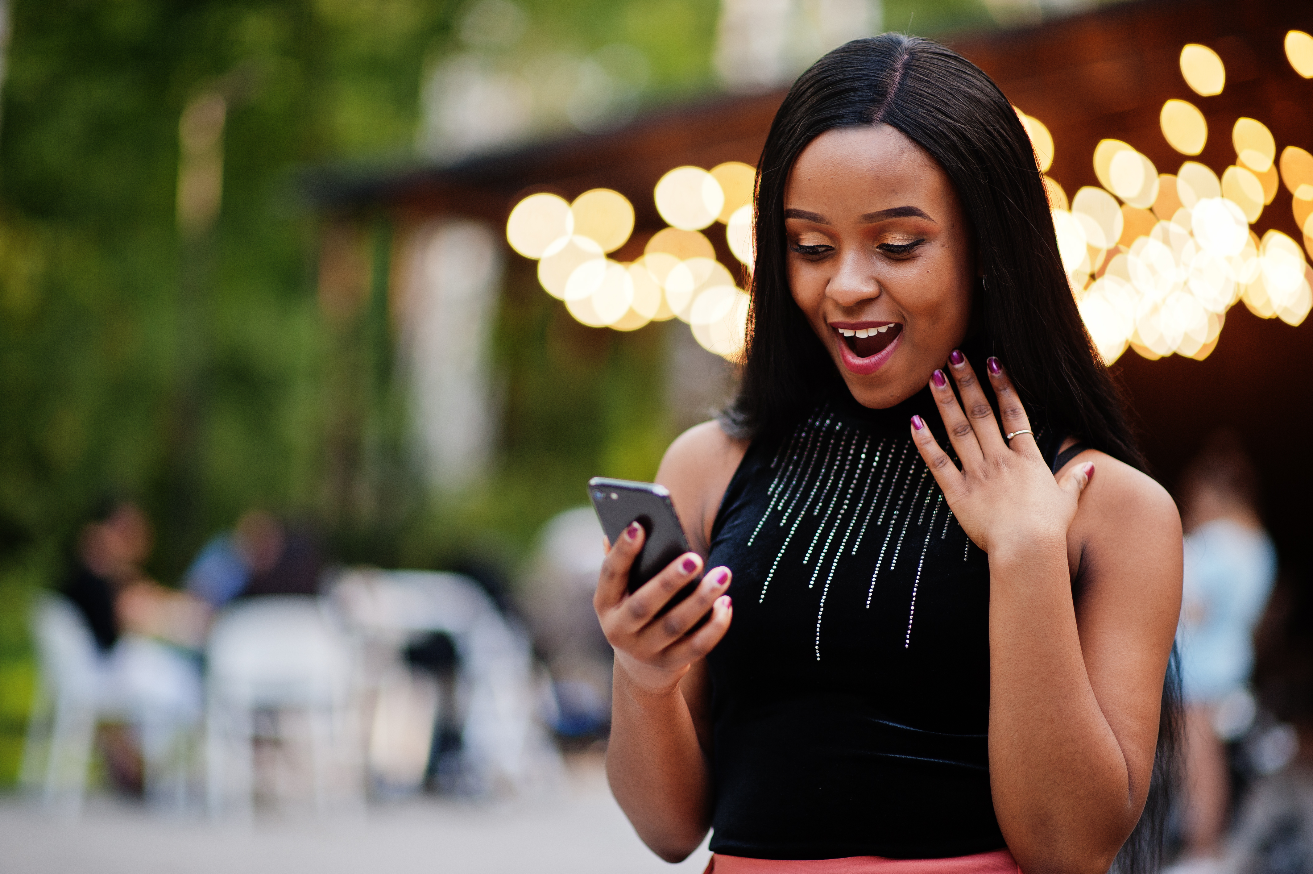 Why tchapeu, fashionable-african-american-woman-peach-pants-black-blouse-look-mobile-phone